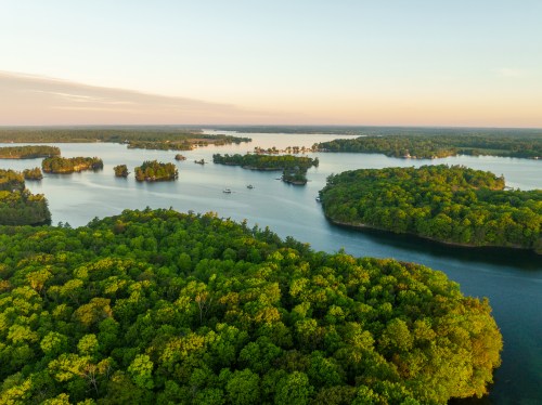 Aerial view of lush green islands surrounded by calm blue waters under a clear sky.