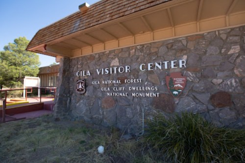 Signage for the Gila Visitor Center, featuring stone walls and information about Gila National Forest and Cliff Dwellings.