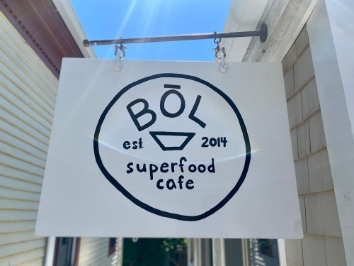 Sign for BŌL Superfood Cafe, established in 2014, featuring a simple logo on a white background.