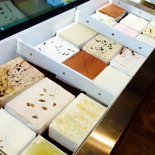 A variety of ice cream flavors displayed in a freezer, with colorful tubs arranged in neat rows.