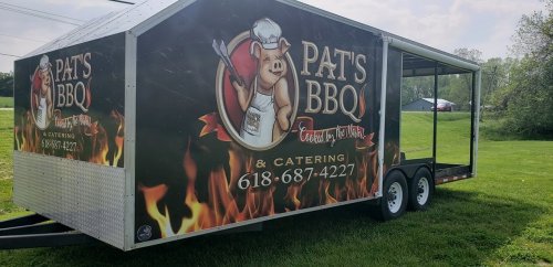 A food trailer with a pig logo, advertising "Pat's BBQ & Catering" with contact information on the side.