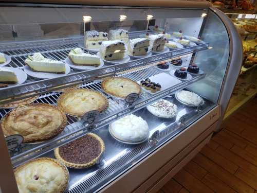 A display case filled with various desserts, including pies, cakes, and pastries, all beautifully arranged.