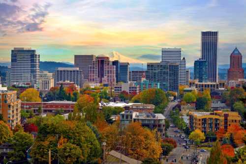 A vibrant city skyline with autumn foliage, featuring tall buildings and a mountain in the background under a colorful sky.