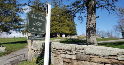 Signpost for "West Haven" at 5798 Main Road, with a stone wall and trees in the background. Invited guests only.