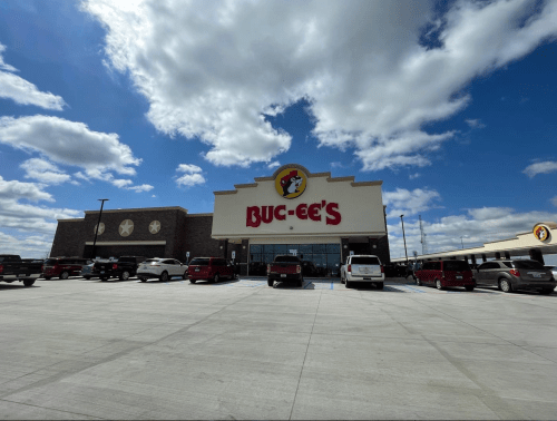 A Buc-ee's convenience store with a large parking lot under a partly cloudy sky.