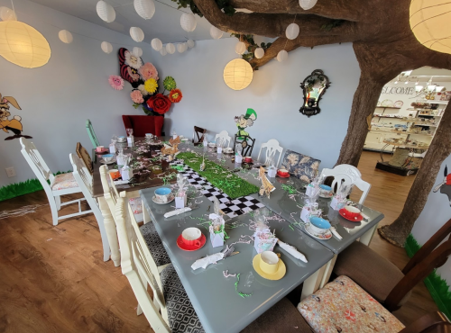 A whimsical dining room with a tree, colorful decor, and a festive table set for a celebration.