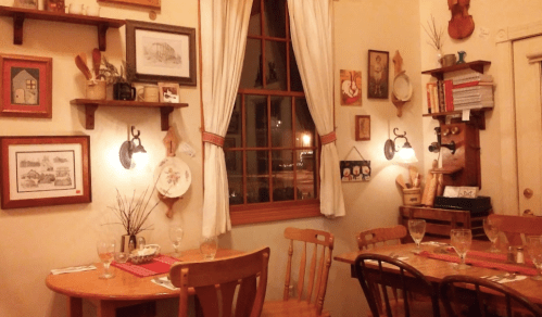 Cozy restaurant interior with wooden tables, vintage decor, and warm lighting, creating an inviting atmosphere.