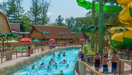 A vibrant water park scene with a lazy river, water slides, and people enjoying the sun and water activities.