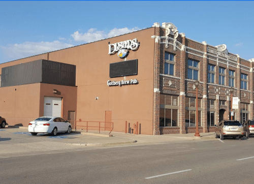 Exterior of a brew pub with a sign reading "Gothberg Brew Pub," featuring a brick building and parked cars.
