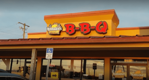 Sign for BubbaQue's BBQ restaurant, featuring a colorful logo and large letters on a building exterior.