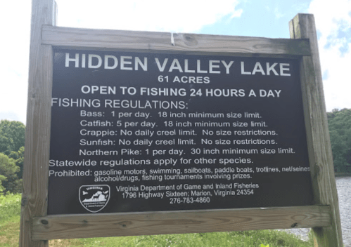 Sign at Hidden Valley Lake detailing fishing regulations, including species limits and contact information.