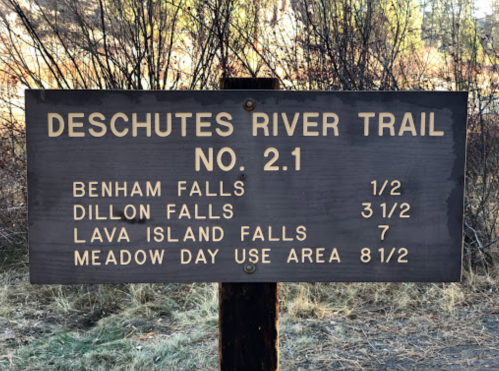 Sign for Deschutes River Trail No. 2.1, listing distances to Benham Falls, Dillon Falls, Lava Island Falls, and Meadow Day Use Area.