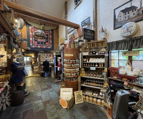 A cozy shop interior filled with shelves of honey jars, rustic decor, and a welcoming atmosphere.