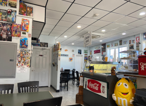 A colorful diner interior with comic book decor, a service counter, and tables for dining.
