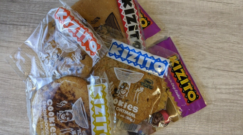 A pile of packaged cookies labeled "Kizito," featuring oatmeal cookies and colorful wrappers.