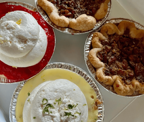 Four dessert pies: two with creamy fillings topped with green garnish, one with red jelly, and one with a nutty filling.