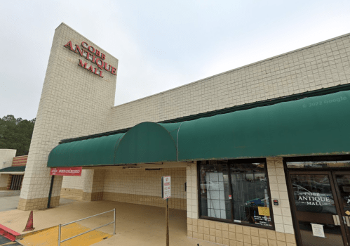 Exterior of Cobb Antique Mall featuring a green awning and large signage on a beige building.