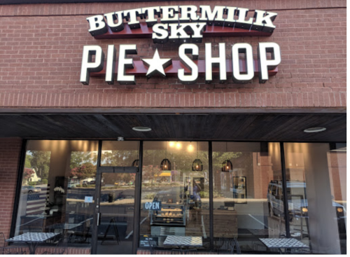 Exterior of Buttermilk Sky Pie Shop with a welcoming "Open" sign and outdoor seating.