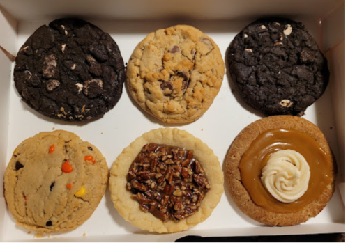 A box of six assorted cookies, including chocolate chip, peanut butter, and pecan pie flavors.