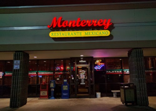 Exterior of Monterrey Restaurante Mexicano, featuring a brightly lit sign and colorful window displays.