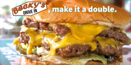A close-up of a double cheeseburger with melted cheese and lettuce, featuring the text "Becky's Drive In, make it a double."