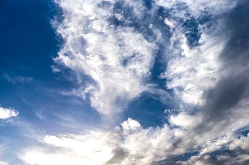 A dramatic sky filled with wispy clouds, blending shades of blue and white, creating a serene atmosphere.