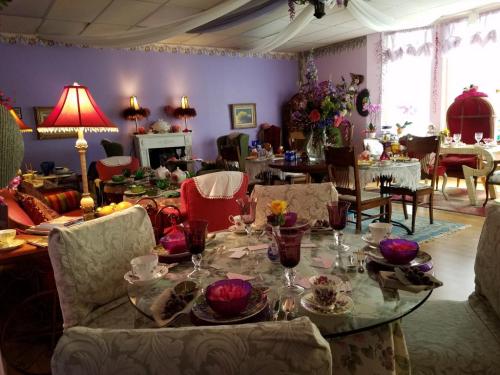 A cozy dining room with elegantly set tables, colorful decor, and floral arrangements in a warm, inviting atmosphere.