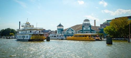 A view of boats docked by a waterfront building under a clear blue sky.