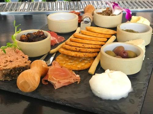 A gourmet cheese and charcuterie board featuring crackers, olives, meats, and spreads, elegantly arranged on a slate.