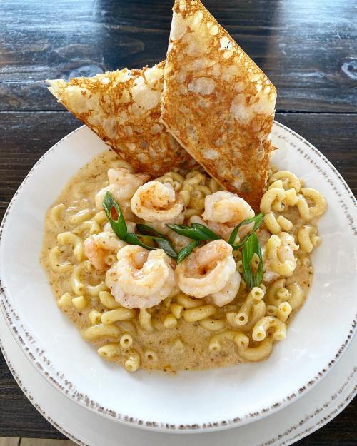 Creamy macaroni pasta topped with shrimp and green onions, served with crispy flatbread on the side.