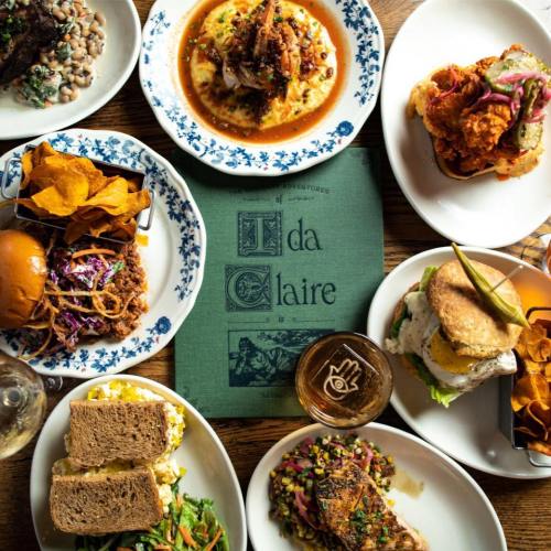 A vibrant spread of various dishes, including fried chicken, sandwiches, and sides, arranged around a menu at a restaurant.