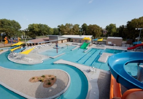 Aerial view of a vibrant water park featuring slides, pools, and lounge areas surrounded by greenery.