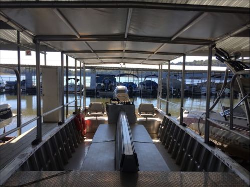 View from inside a boat at a marina, with other boats docked in the background and water visible.