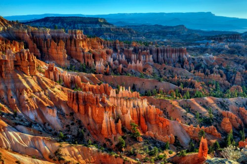 Vibrant rock formations and hoodoos in a colorful canyon landscape under a clear blue sky.