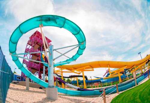 A colorful water slide complex with twisting slides and a tall tower under a bright sky.