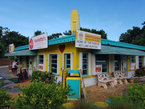 Colorful exterior of Harriette's Restaurant, featuring signs for key lime muffins and a welcoming "Open" display.