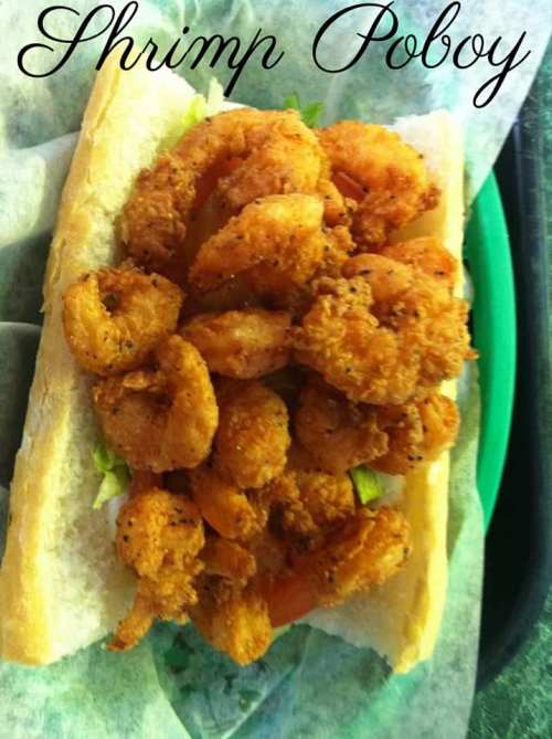 A shrimp po'boy sandwich filled with crispy fried shrimp, lettuce, and served on a soft hoagie roll.