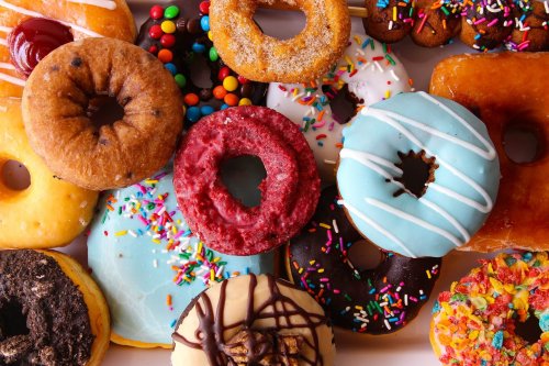 A colorful assortment of donuts with various toppings, including sprinkles, icing, and chocolate.