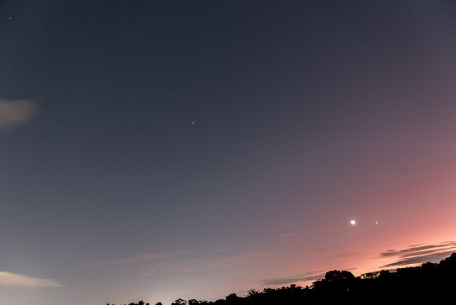A twilight sky filled with stars, featuring a bright planet and a gradient of colors from dark blue to soft pink.