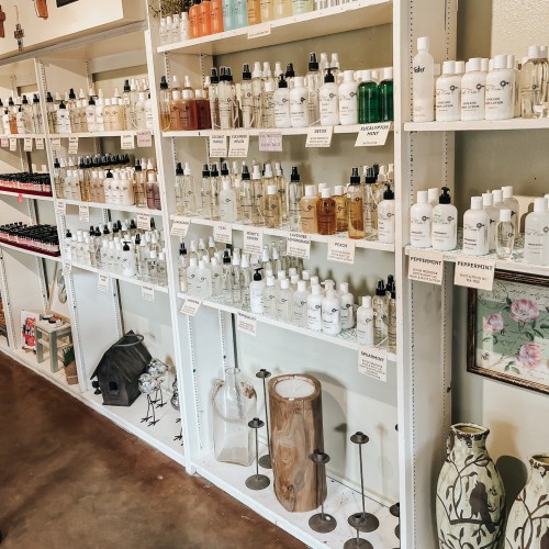 Shelves filled with various bottles of skincare products and essential oils, neatly labeled and organized.