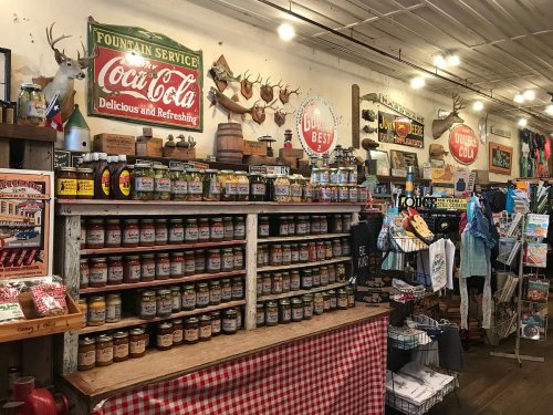 A rustic store interior featuring shelves of jars, vintage signs, and decorative items, creating a nostalgic atmosphere.