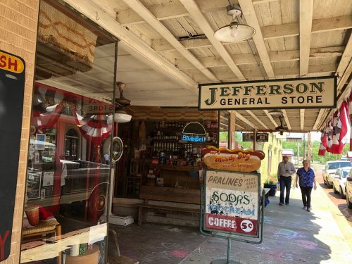 A quaint general store with a sign reading "Jefferson General Store," featuring vintage decor and people walking by.