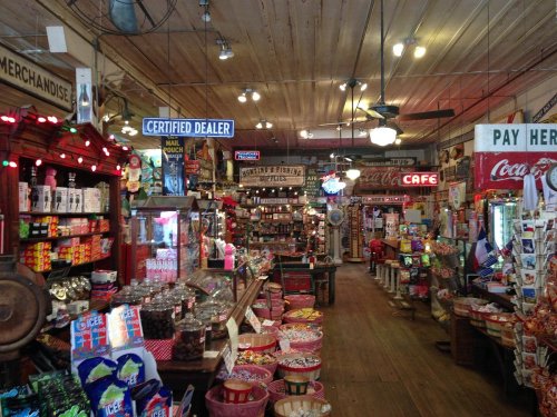 A colorful vintage store filled with various merchandise, candy, and nostalgic signs, creating a lively atmosphere.