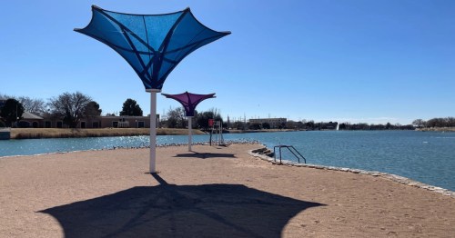 shade structures on the sandy beach at lake carlsbad rec area in carlsbad new mexico