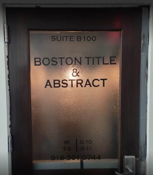 Frosted glass door with "Boston Title & Abstract" and suite number B100, featuring business hours and phone number.