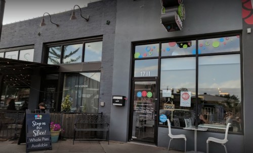 Exterior of a colorful storefront with large windows, a sign for "Poke" and a chalkboard menu outside.