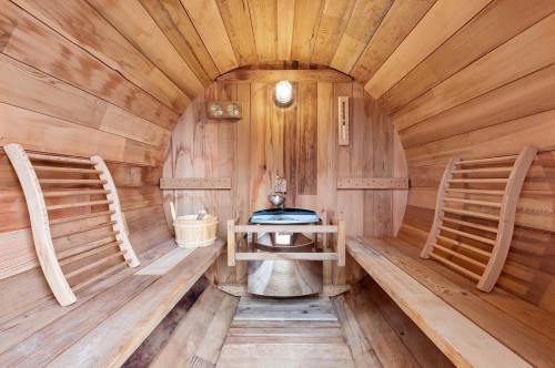 A wooden sauna interior featuring two benches, a small table, and a warm, inviting atmosphere.