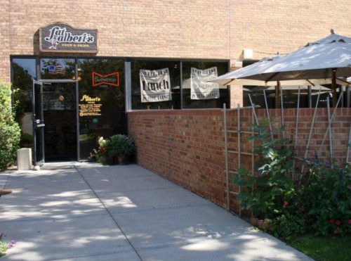 Exterior view of Fat Albert's Food & Drink, featuring a brick facade, outdoor seating, and a sign above the entrance.