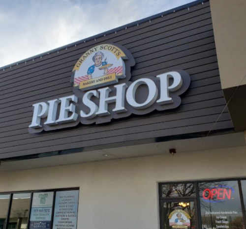 Sign for Granny Scott's Pie Shop, featuring "PIE SHOP" prominently, with an "OPEN" sign in the window.