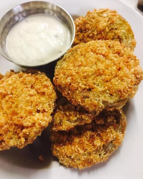 Crispy fried green tomatoes served with a small bowl of creamy dipping sauce.